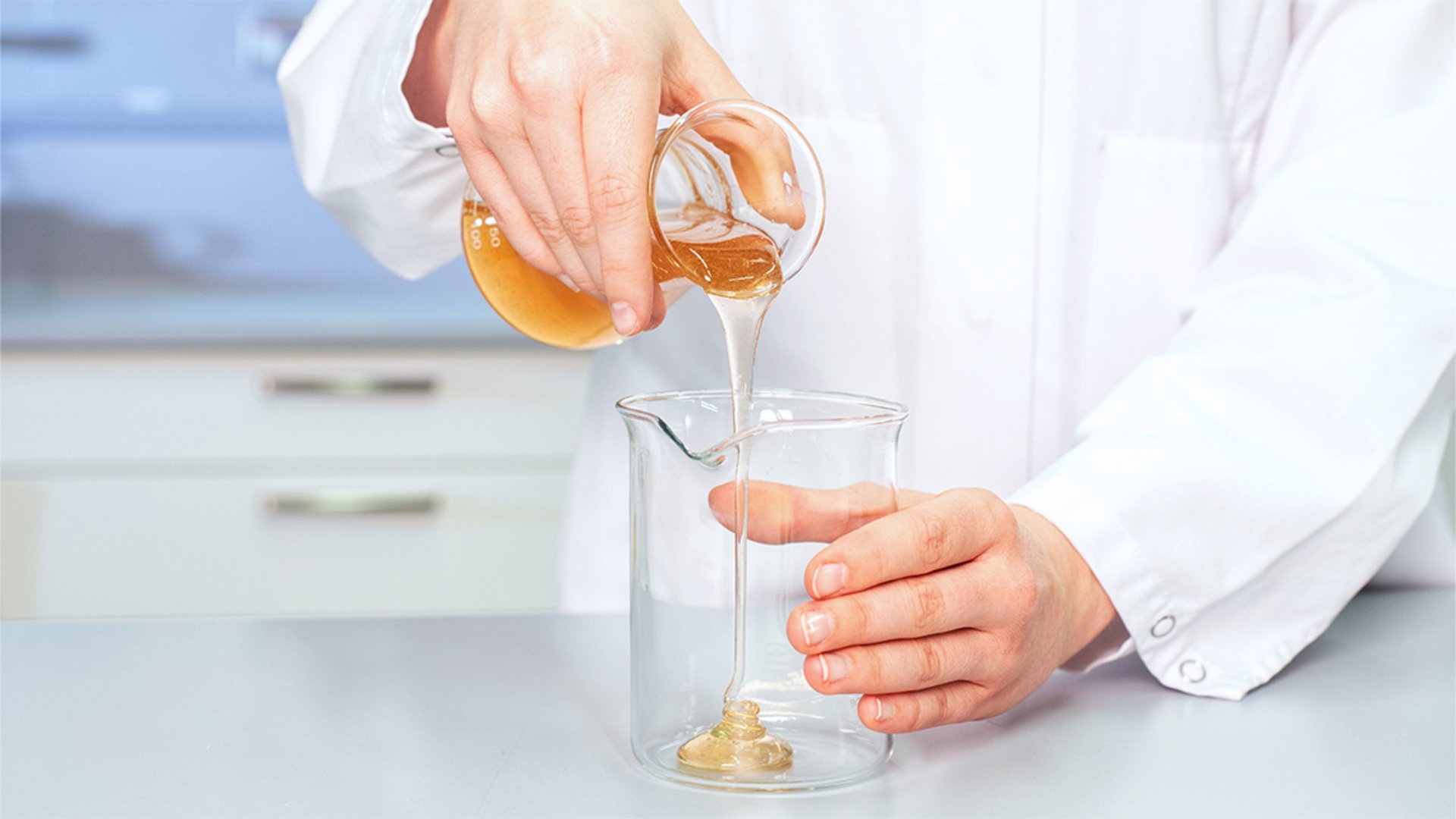 Die BOLDER Arzneimittel Bildwelt zeigt eine Laborantin aus der Produkt Entwicklung, die eine Masse in ein Glasgefäß gießt.