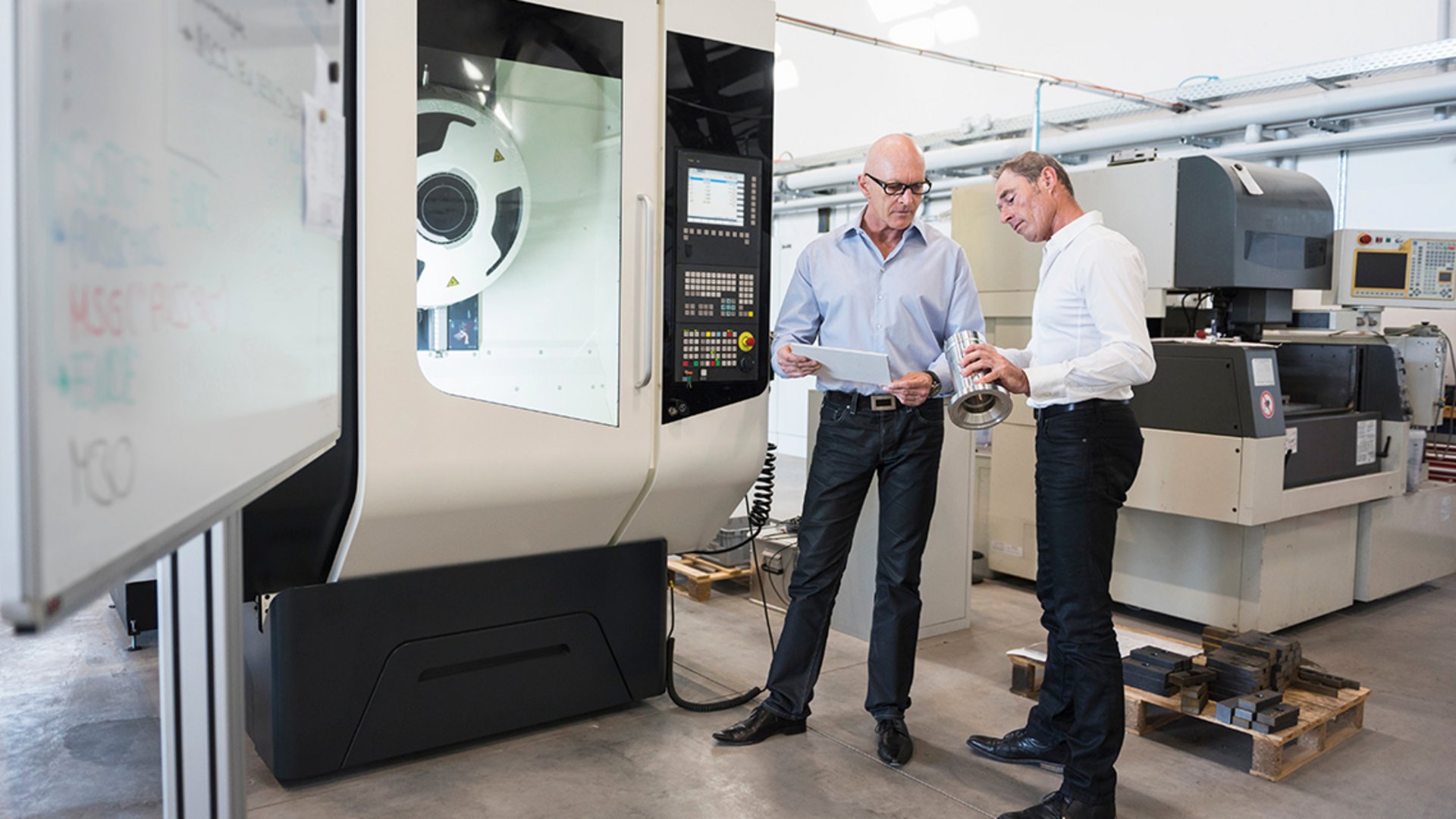 Zwei Mitarbeiter eines Industriebetriebes begutachten ein geliefertes Produkt und befinden sich an einem kritischen Punkt ihrer Customer Journey.