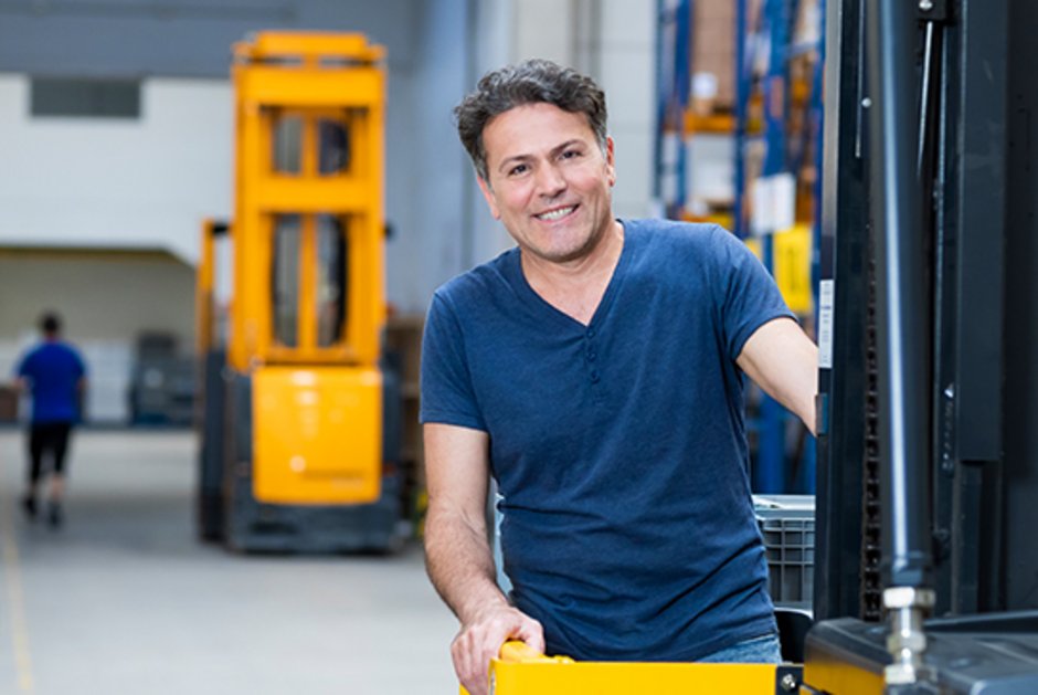 Mitarbeiter auf einem Gabelstapler im Logistikzentrum von DAHLHAUSEN Medizintechnik.