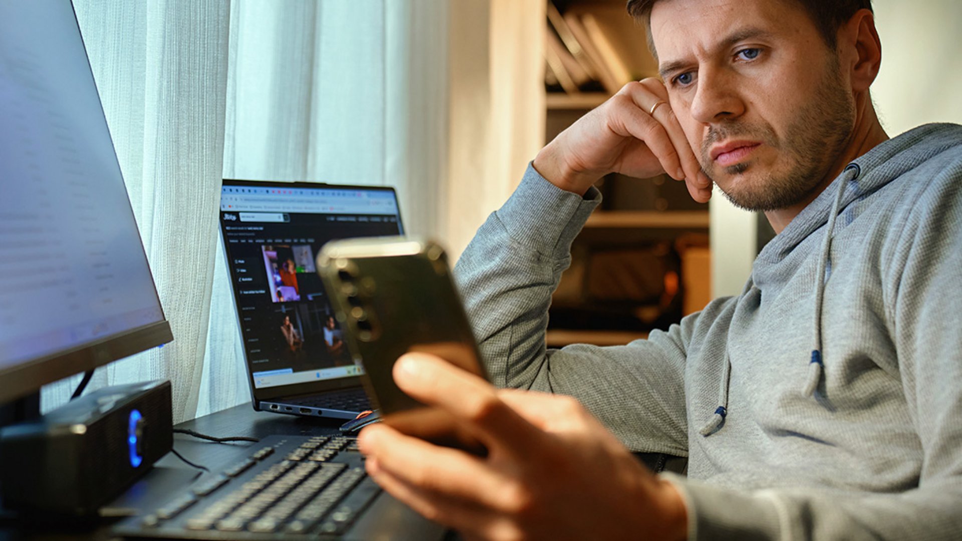 Ein gestresster T-Systems-/Telekom-Mitarbeiter erhält eine Phishing-Mail über sein Smartphone.