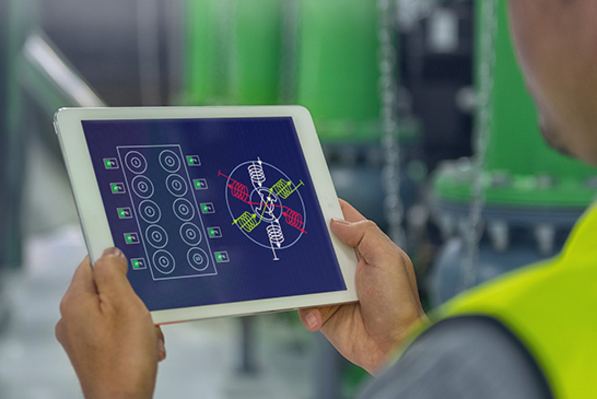 Ein Ingenieur betrachtet auf einem Tablet ein Dashboard, das den Ladezustand der Schwungräder anzeigt.