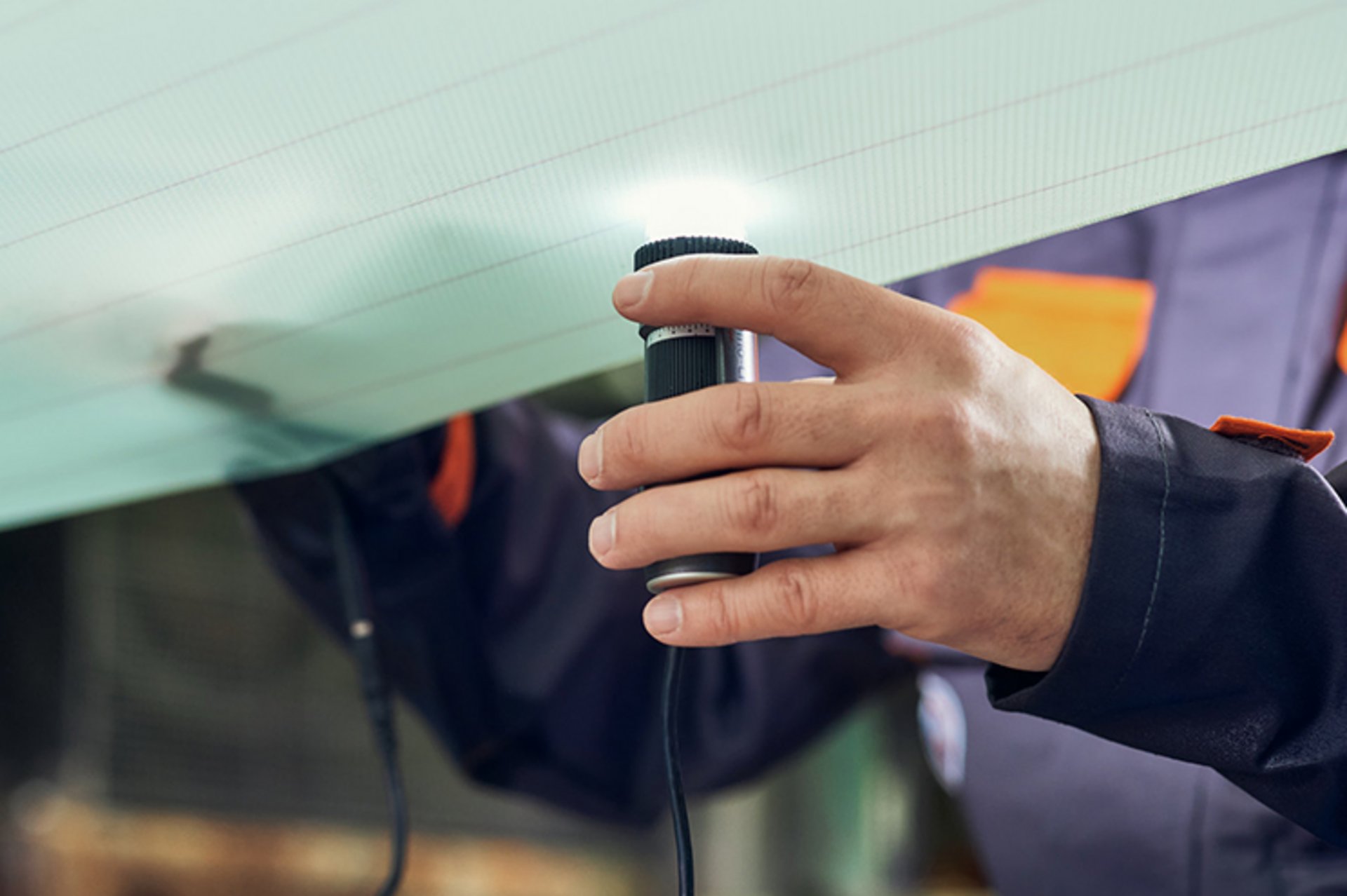 Ein Mitarbeiter des technischen Services von Heimbach nimmt mittels Licht eine optische, berührungslose Nasssiebmessung an der Papiermaschine vor.