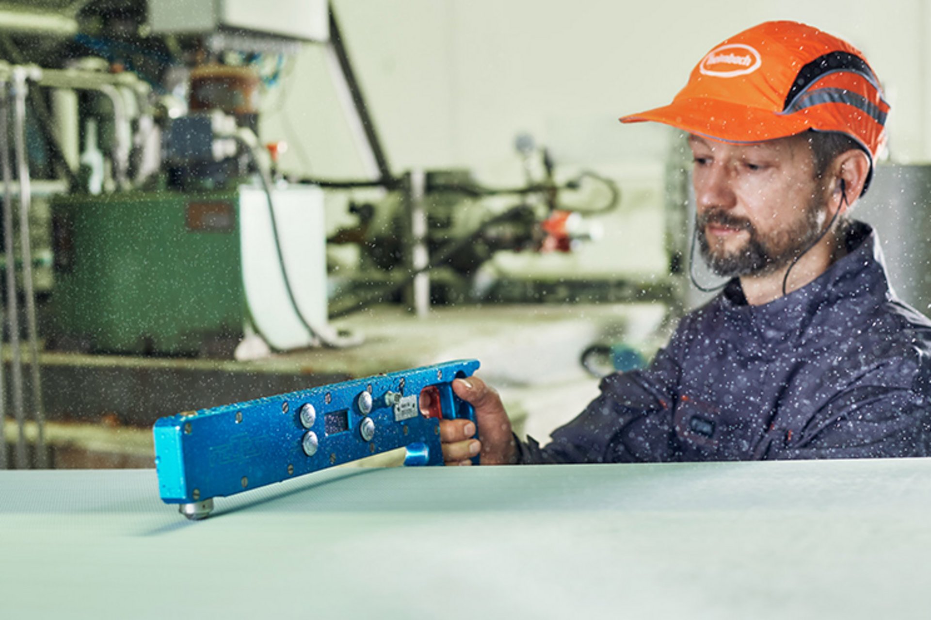 Ein Mitarbeiter des technischen Services von Heimbach nimmt mithilfe einer Dickenmessgabel eine mechanische Nasssiebmessung an der Papiermaschine vor.