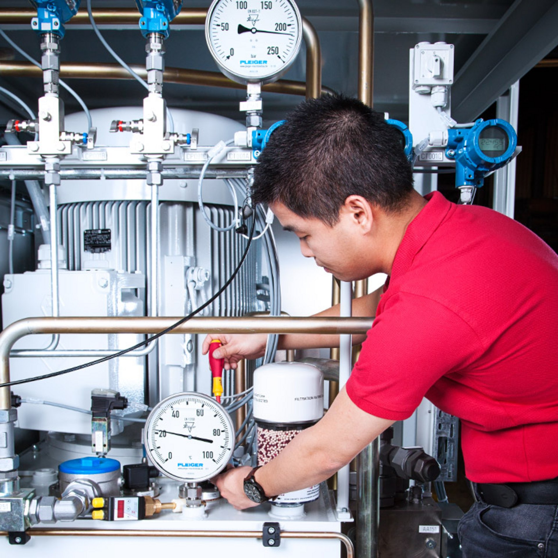 Ein BÜHLER Technologies Techniker baut eine Komponente in eine Anlage ein.