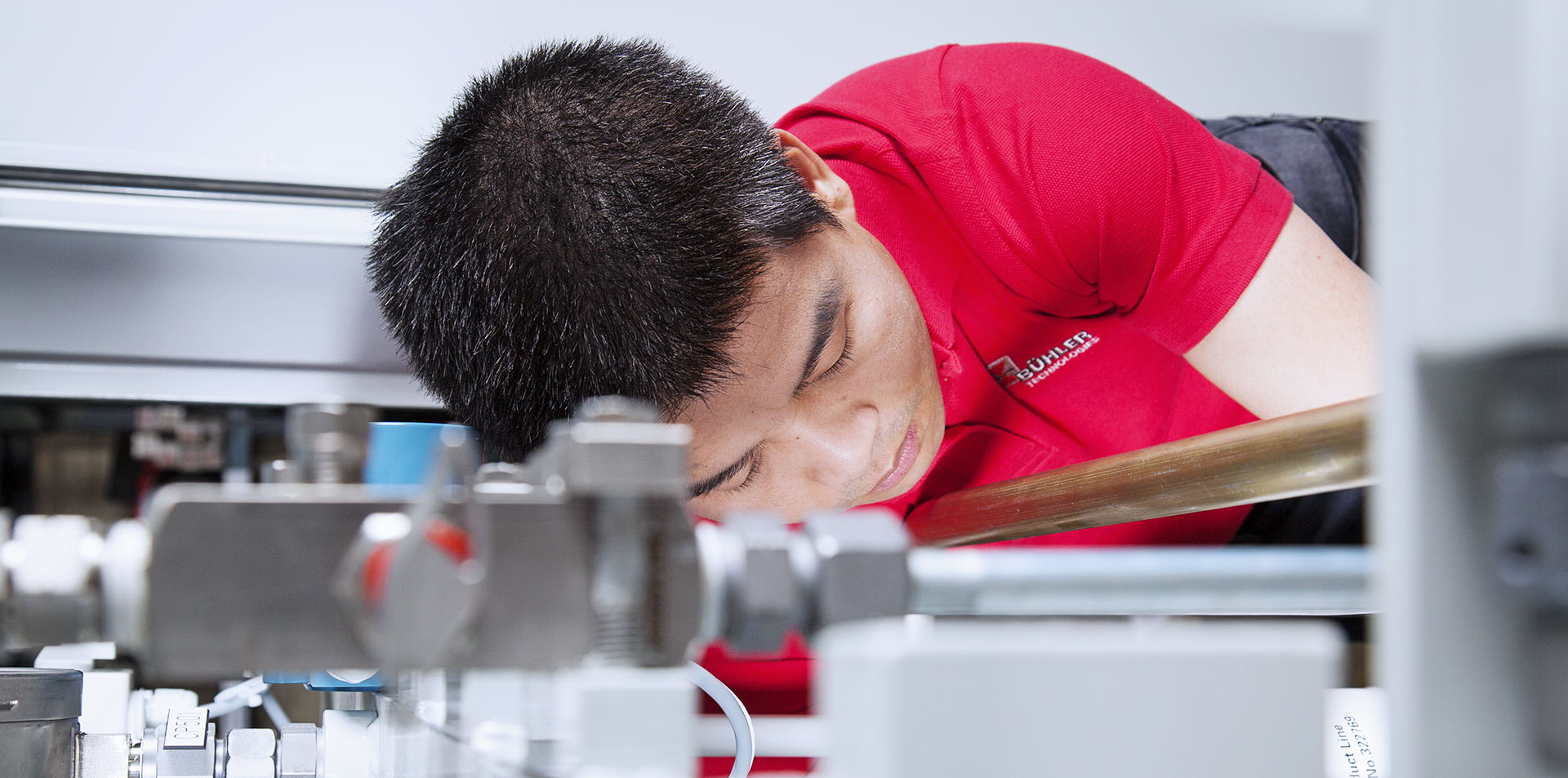 Ein BÜHLER Technologies Monteur baut Messtechnik in eine Anlage ein.